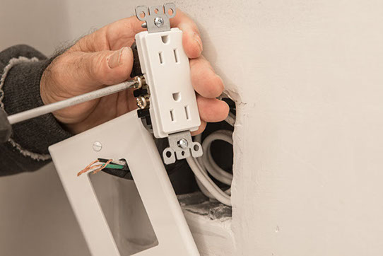 hands wiring an electrical outlet